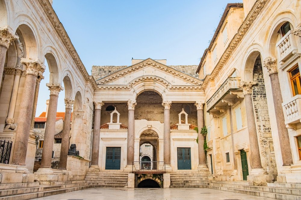 The Palace Of Diocletian - A stone building with columns and a stone walkway, recognized as one of the UNESCO World Heritage Sites in Croatia.